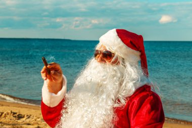 Noel Baba sahilde bir puro içiyor.