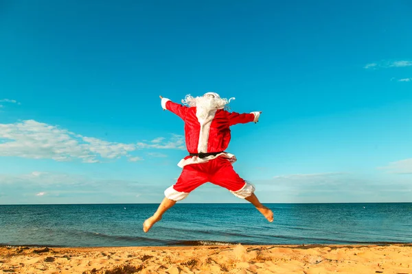 Santa Claus skacze na plaży. — Zdjęcie stockowe