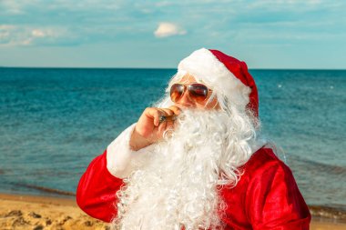 Noel Baba sahilde bir puro içiyor.