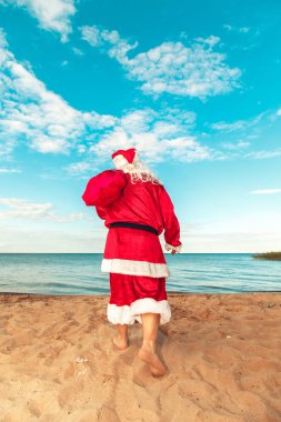 Noel Baba hediye sahilde bir çanta. Bedeni sembolü