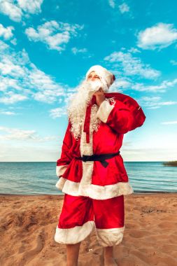 Noel Baba hediye sahilde bir çanta. Bedeni sembolü