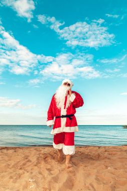 Noel Baba hediye sahilde bir çanta. Bedeni sembolü