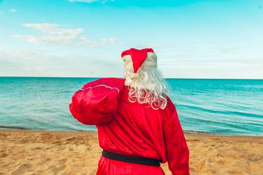 Noel Baba hediye sahilde bir çanta. Bedeni sembolü