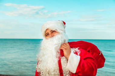 Noel Baba hediye sahilde bir torba ile. 