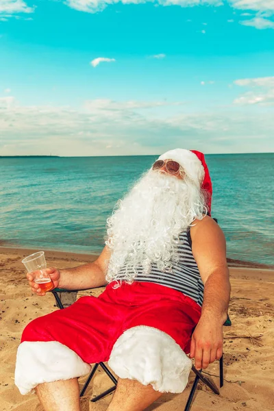 Noel Baba sahilde oturuyor. 