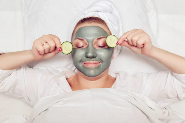 Attractive funny woman with a clay mask on her face. — Stock Photo, Image