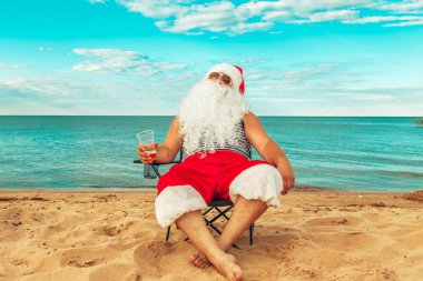 Noel Baba sahilde oturuyor. 