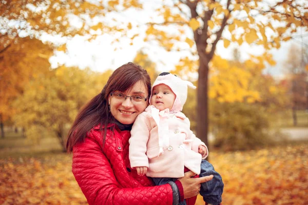 Mamá con un niño jugando en el parque de otoño . —  Fotos de Stock