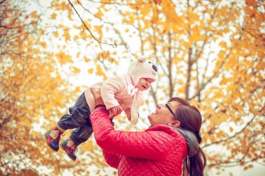 Sonbahar parkta oynayan bir çocuk ile anne. 