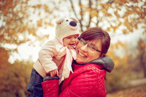 Mamá con un niño jugando en el parque de otoño . —  Fotos de Stock