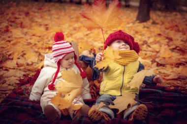 Küçük çekici çocuklar sonbahar parkta oynamak.