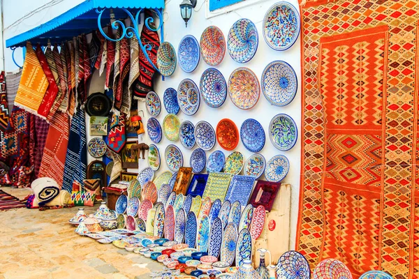 Artefactos de barro e tapetes de recordação no mercado tunisiano . — Fotografia de Stock