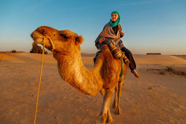 Frau reitet auf Kamel in der Sahara-Wüste. — Stockfoto