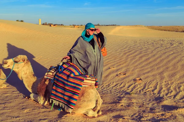 Vrouw met een kameel in de Saharawoestijn. — Stockfoto