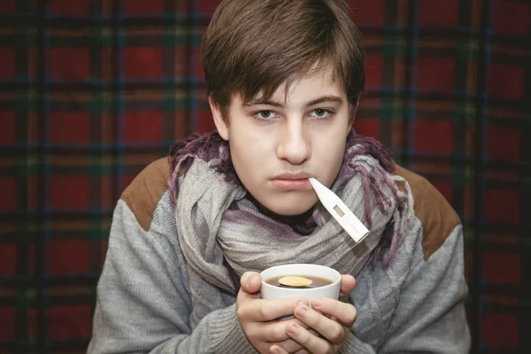 Sick teenager with a thermometer at home. — Stock Photo, Image