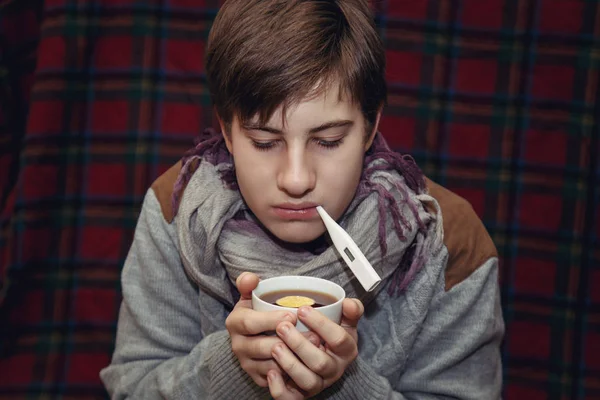 Chory nastolatek z termometrem w domu. — Zdjęcie stockowe