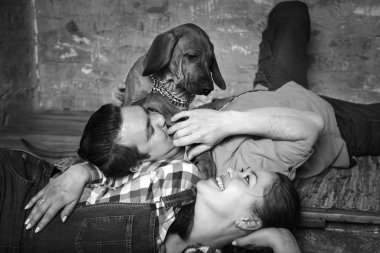 Onların köpekle oynayan genç mutlu aile.