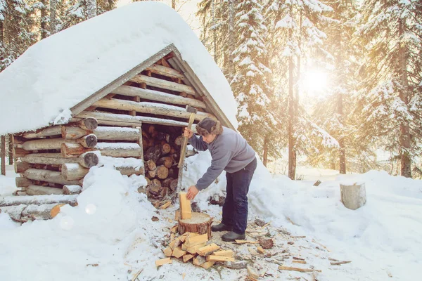 Man hugga ved i skogen nära stugan. — Stockfoto