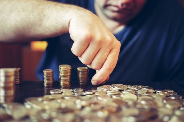 Adam sikke yığını yığar. 