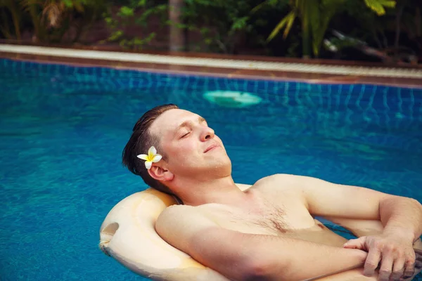 El hombre se relaja en la piscina . — Foto de Stock