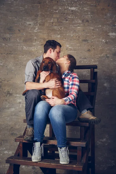 Spelen met hun pup en jonge gelukkige familie. — Stockfoto