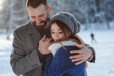 Karlı kış ormanlarında yürüyen, Noel tatilini birlikte geçiren mutlu bir çift. Açık havada mevsimlik aktiviteler. Yaşam stili yakalama.