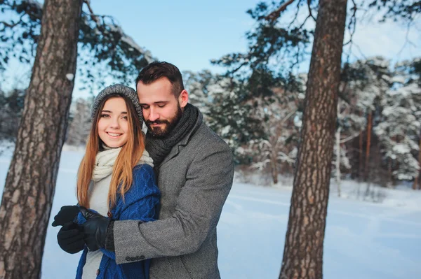 Счастливая любящая пара, гуляющая в снежном зимнем лесу, проводящая рождественские каникулы вместе. Мероприятия на открытом воздухе. Захват образа жизни. — стоковое фото