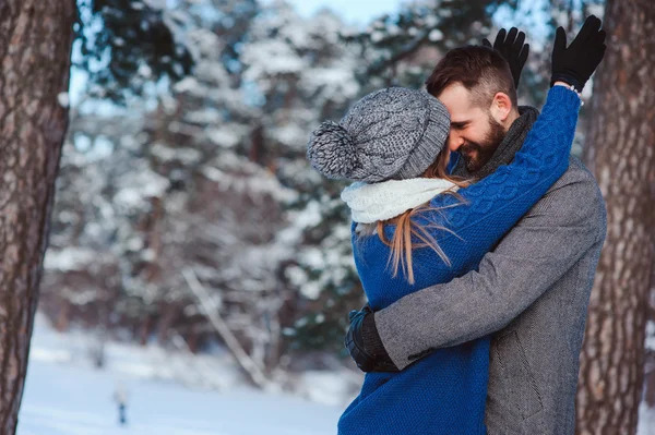 Felice coppia amorevole passeggiando nella foresta invernale innevata, trascorrendo le vacanze di Natale insieme. Attività stagionali all'aperto. Cattura stile di vita. — Foto Stock