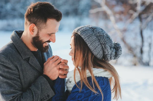 Lifestyle-Aufnahme eines jungen glücklichen Paares, das im verschneiten Wald spazieren geht und seinen Winterurlaub im Freien verbringt — Stockfoto
