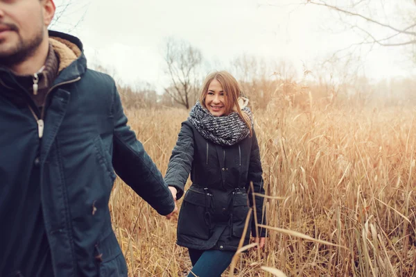 Amando jovem casal feliz juntos ao ar livre em acolhedor passeio quente na floresta de outono — Fotografia de Stock