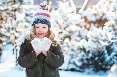 tatile kar karlı kış yürüyüş Bahçe, mevsimlik açık hava etkinlikleri içinde oynamaktan mutlu çocuk kız