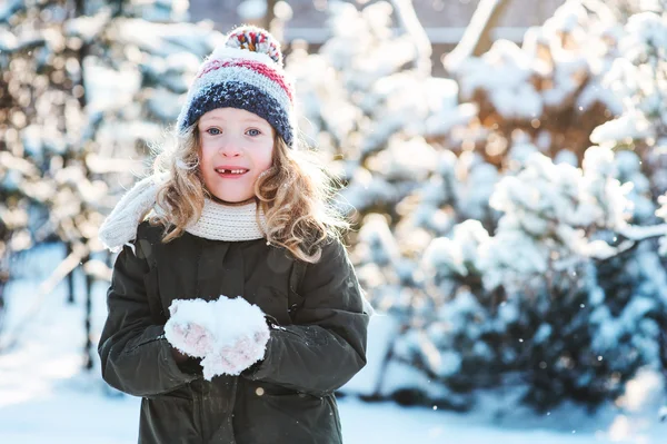 Щаслива дівчина, яка грає зі снігом на зимовій засніженій прогулянці в саду, сезонні активності на відкритому повітрі у відпустці — стокове фото