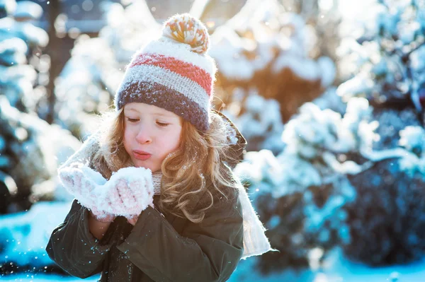 Niña feliz jugando con nieve en invierno paseo nevado en el jardín, actividades al aire libre de temporada en vacaciones — Foto de Stock