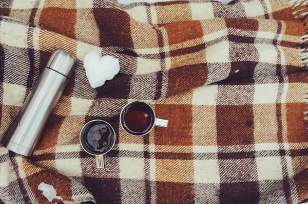 Winter picnic on the snow. Hot tea, thermos and snowball heart on cozy warm blanket. Outdoor seasonal activities. — Stock Photo, Image