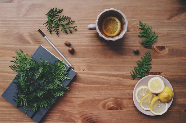 Puncak tampilan notebook dan cabang pinus dengan secangkir teh dengan lemon — Stok Foto