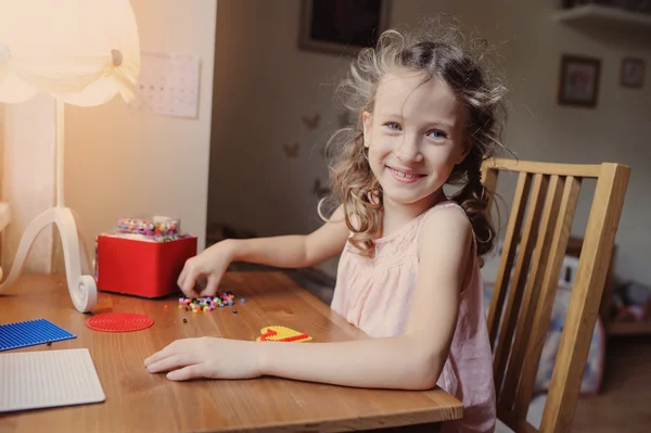 Happy child girl playing with mosaic at home in her room — Stock Photo, Image