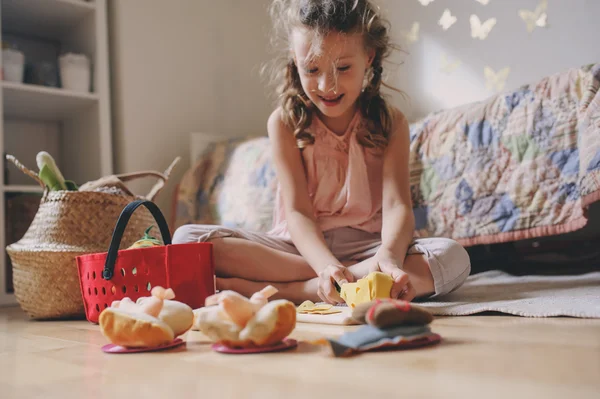 Little child girl playing in her room with toy food, cooking and having fun at home — Stock Photo, Image