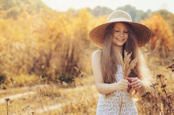 Mutlu bir çocukluk kız yaz sahada eğleniyor saman. Çocuklu yaz açık hava etkinlikleri — Stok fotoğraf