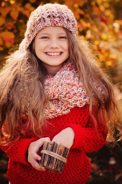 Happy child girl in knitted scarf and sweater with basket on autumn walk in forest — Stock Photo, Image