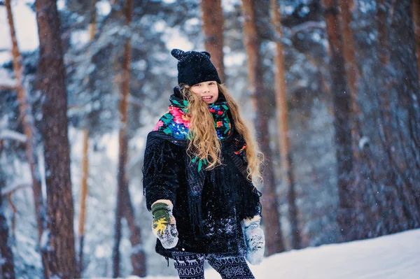 Winterporträt eines glücklichen Mädchens beim Spazierengehen im verschneiten Wald — Stockfoto