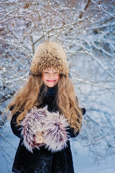 Lyckligt drömmande barn flicka vandrar i snörik vinter skog — Stockfoto