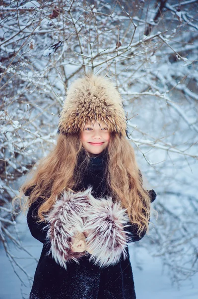 Happy dreamy child girl walking in snowy winter forest — Stock Photo, Image