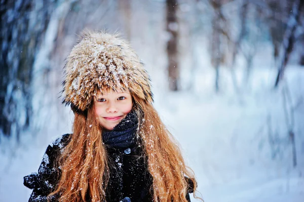 Vinter porträtt av happy kid flicka vandrar i snöiga skogen — Stockfoto