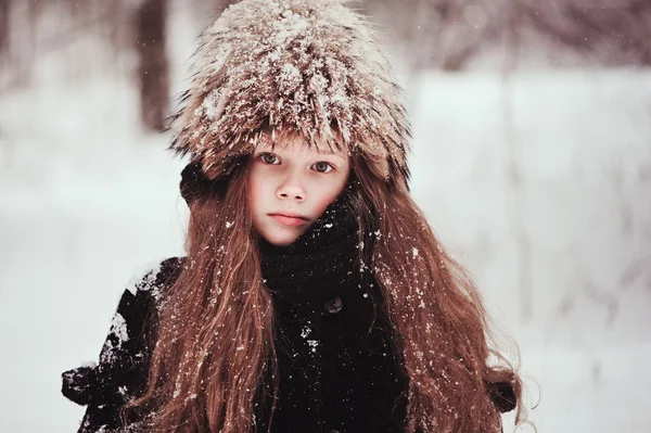 Счастливый мечтательный ребенок девочка ходить в снежном зимнем лесу — стоковое фото