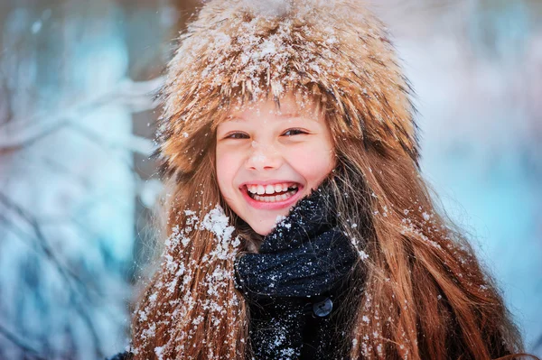 Portret szczęśliwy dziewczyna spaceru w lesie snowy zimowych — Zdjęcie stockowe