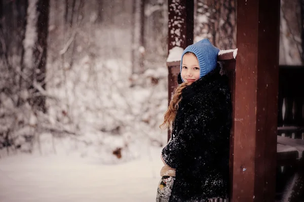 Vinter porträtt av happy kid flicka vandrar i snöiga skogen — Stockfoto