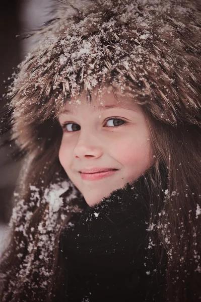 Lyckligt drömmande barn flicka vandrar i snörik vinter skog — Stockfoto