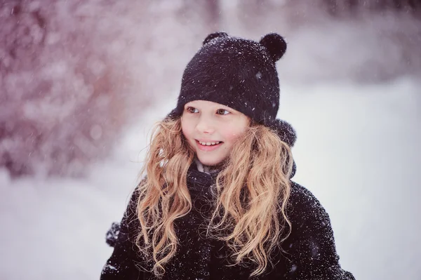 Lyckligt drömmande barn flicka vandrar i snörik vinter skog — Stockfoto