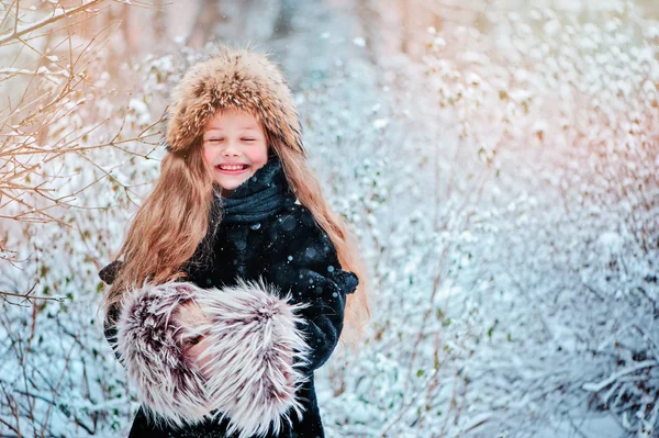 Счастливый мечтательный ребенок девочка ходить в снежном зимнем лесу — стоковое фото