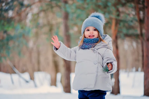 Carino felice bambina a piedi nella foresta invernale — Foto Stock